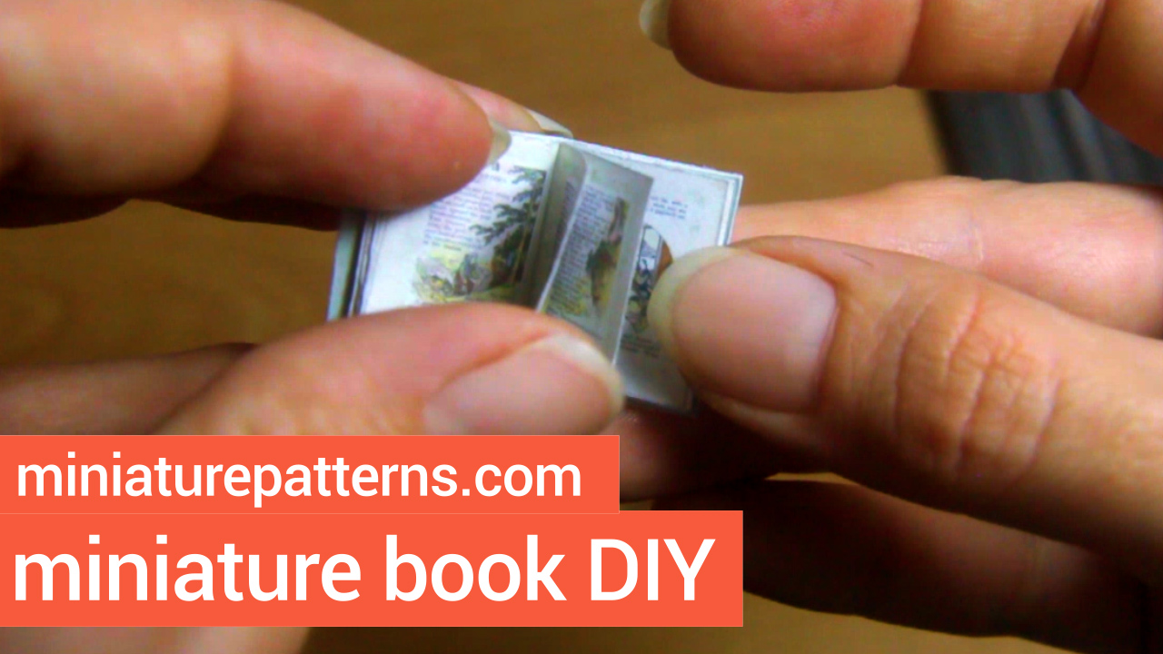 A miniature version of the book Japanese Fairy Tales being held open to a page with trees and mountains